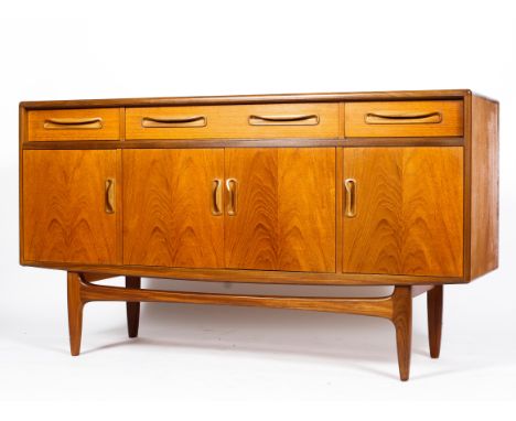 A mid-century G-Plan teak sideboard, with three drawers above a central double door enclosing a single shelf, flanked by two 