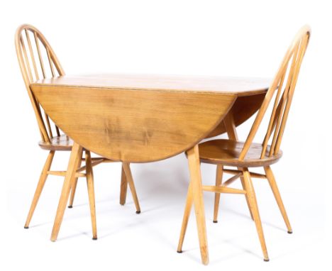 An Ercol light elm and beech drop-leaf dining table and two spindle back chairs on splayed feet, the table 72.5 cm high x 113