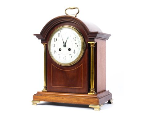 An early 20th century inlaid  mahogany mantel clock with gilt column supports and feet, white enamel face with Arabic markers