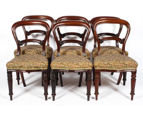 A set of six Victorian mahogany balloon-back dining chairs, with carved foliate back rest, with floral tapestry style stuff-o