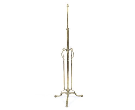 An Edwardian brass standard lamp, with scroll cast pierced uprights, on tripod base and ball feet, fitted for electricity, 14