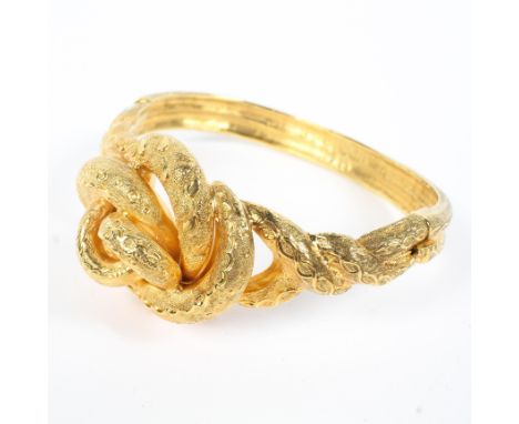 An unmarked yellow metal knot bangle bracelet. 31.3g. Internal 6cm. 