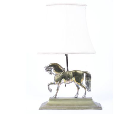 A brass lamp base cast as a horse on waisted plinth base, fitted for electricty, with cream shade, 49.5cm high 