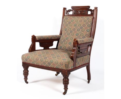 A Victorian mahogany framed armchair, the top rail carved with gadroons and acanthus, upholstered in tapestry style fleur-de-