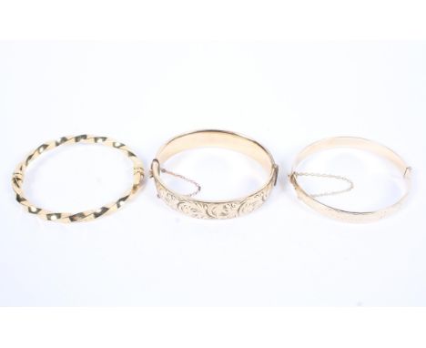 Two 9ct gold metal core bangles together with an unmarked yellow metal bangle. 