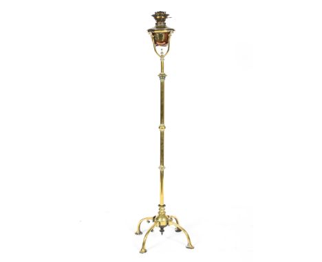 An Arts and Crafts standard lamp, in the style of W. A. S. Benson, mounted with copper-embossed leaves, raised on a shaped tr