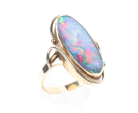 A 15ct gold black opal dress ring, oval black opal triplet in bezel setting. 5.8g Size S. 