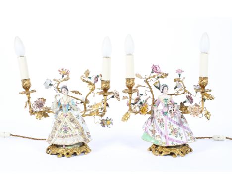 A pair of gilt metal and Continental porcelain twin-light candelabra, each mounted with a Meissen style figure of a crinoline