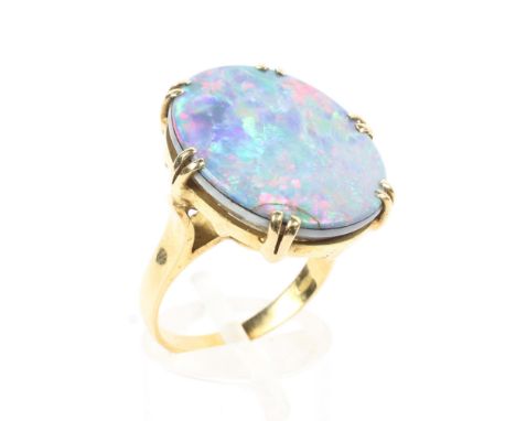 An 18ct gold 750 marked opal doublet ring. Central oval black opal panel in double six claw setting. 7.6g. Size N. 