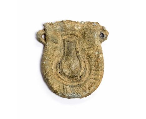 Medieval lead flask-shaped pilgrim's ampulla. One face bears an image of a pouch with hatching below, the other has a large a