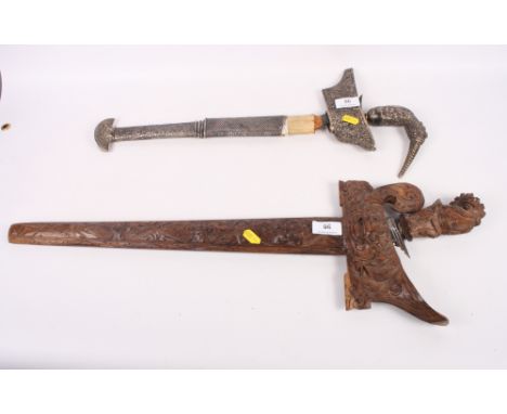 A kris with wood and white metal mounted handle and scabbard, together with a similar carved wooden kris, Damascus blades