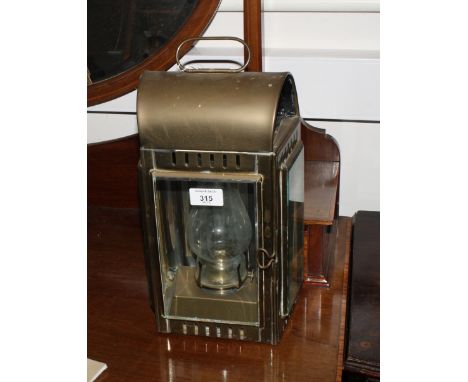 A brass wall mounted lantern with carry handle