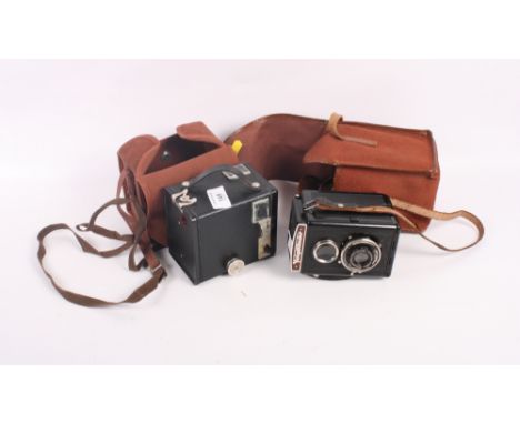 A Voigtlander twin lens reflex camera, in Bakelite case, and a Kodak box six-20 Brownie D, both in canvas cases