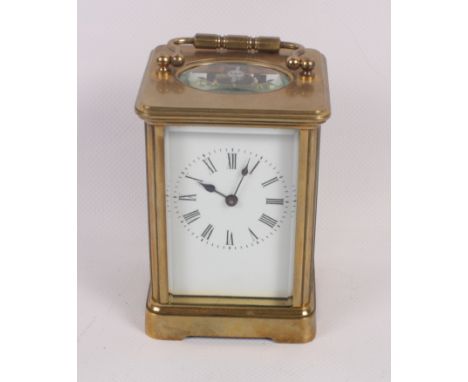 A brass cased carriage clock with white enamel dial and Roman numerals, 4 1/2" high