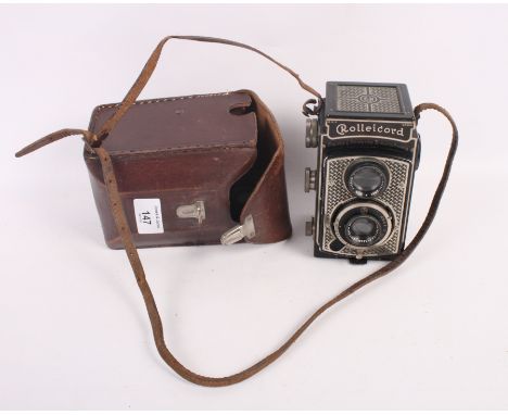 A Rolleicord twin lens reflex camera with Triotar f4.5 lens, in leather case, and a guidebook