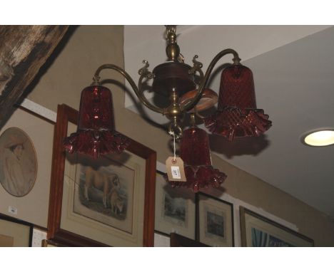 An early 20th Century three-branch ceiling light pendant with ruby glass shades