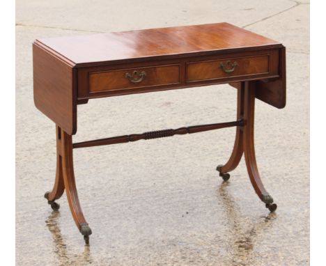 A mahogany sofa table of Georgian design, fitted two drawers, on splay supports with lion paw terminals, 36" wide