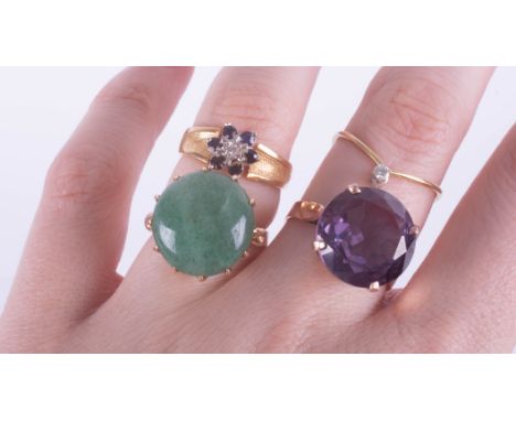 A large amethyst ring, set in gold? indistinct marks, size K, a jade set dress ring, size K, a small diamond set wishbone rin