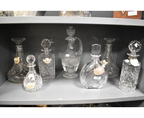 Seven decanters, including cut glass, also included are some decanter tags, Five of which are enamel and one HMS.