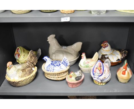 A collection of vintage and modern ceramic and glass hen storage containers and egg baskets and similar.