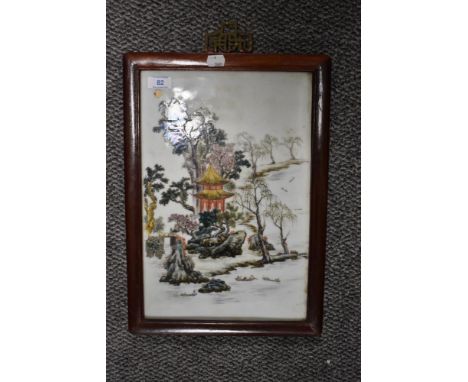 An Early 20th century Chinese ceramic table screen hand decorated in Polychrome, with foliage, pagoda and bridge, enclosed in