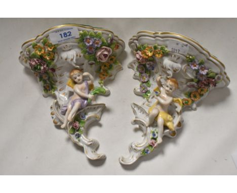 A pair of Sitzendorf porcelain wall brackets with floral and cherub designs