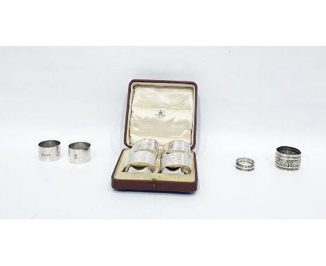 Set of four silver napkin rings by Mappin & Webb, Chester 1919, each of oval form with engine-turned bands and engraved stars