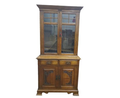 20th century oak bookcase cabinet, the glazed doors enclosing adjustable shelves above two drawers and two cupboard doors, to