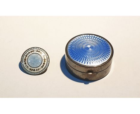 Silver pill box of circular form, the hinged cover set with blue engine-turned enamel, 4cm diameter and an enamel button (2) 