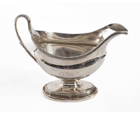 A George III silver sauceboat, R M, London 1795, of helmet-shape with reeded rim, on an oval foot, initialled, 14cm high, app