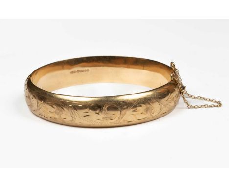 A Victorian style 9ct gold hinged bangle, hallmarked CPS, Birmingham 1972, with engraved scroll decoration, approximately 15.