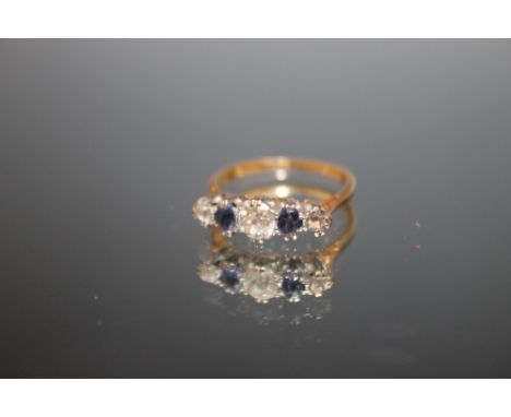 AN 18 CARAT AND PLATINUM FIVE STONE SAPPHIRE AND DIAMOND RING, the central diamond being an estimated half a carat, ring size