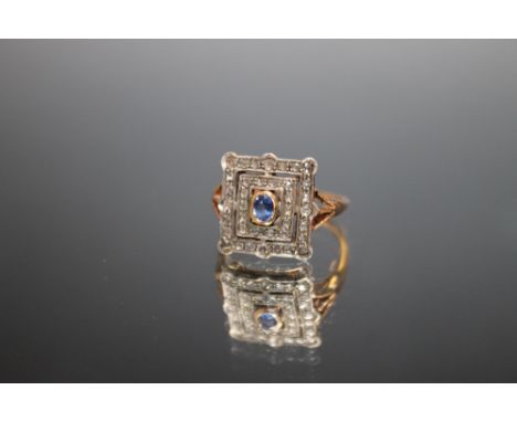 AN UNUSUAL ART DECO STYLE 585 GOLD SAPPHIRE AND DIAMOND RING,  the central oval sapphire being an estimated quarter carat, ri