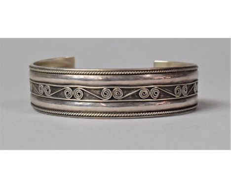 A Silver Bangle with Scrolled Decoration 