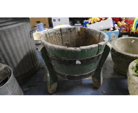 A Circular Wooden Planter Raised on Tripod Legs 