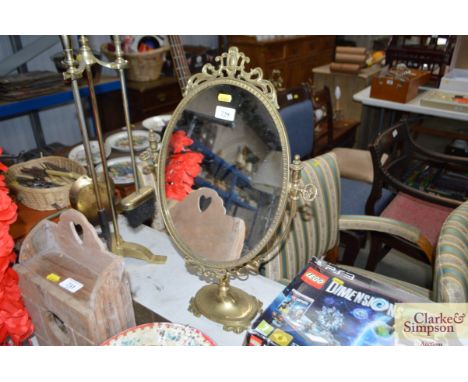 An oval brass coloured metal adjustable dressing table mirror