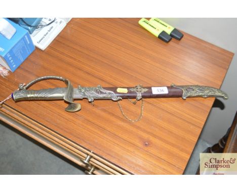 A small decorative sword in scabbard and a decorative knife