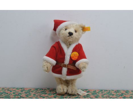 A modern Steiff yellow tag Christmas Teddy bear, blond mohair, known as Noel, on Russ stand, 27cm high 