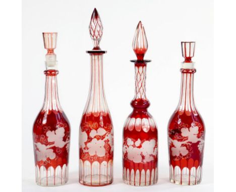 FOUR RUBY FLASHED GLASS BOTTLES AND STOPPERS DECORATED WITH  VINES OVERLAID, 42CM H, 20TH CENTURY 