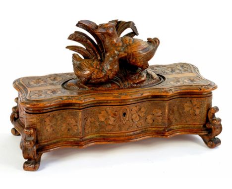 A 19TH CENTURY BLACK FOREST CARVED TRINKET BOX, WITH SERPENTINE FRONT THE LID WITH TWO DUCKS AMONGST RUSHES, ON SCROLL FEET A