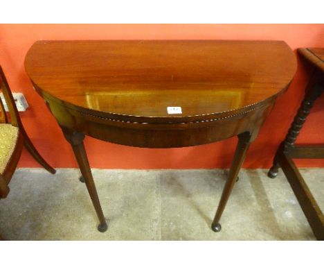 A mahogany demi lune pad foot folding card table with baize lined playing surface, 92cm wide