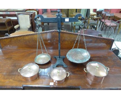 A set of cast iron and copper Avery scales and three copper pans
