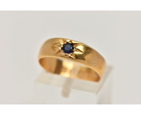 A 22CT GOLD BAND RING, set with a circular cut blue sapphire in a star setting, approximate band width 6mm, hallmarked 22ct B