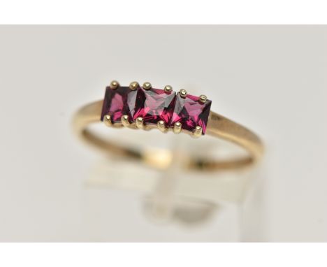 A 9CT GOLD THREE STONE RING, three square cut garnets, each claw set, to a polished yellow gold shank, hallmarked 9ct Birming