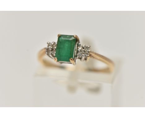 A 9CT GOLD EMERALD AND DIAMOND RING, set with a rectangular cut emerald, four claw set, flanked with two sets of four small s