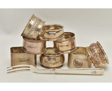EIGHT SILVER NAPKIN RINGS AND A TEA FORK, eight napkin rings of various styles, all with a full silver hallmark from assay of