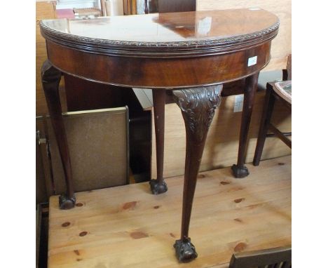 A mahogany demi-lune folding top card table on carved cabriole legs and claw and ball feet