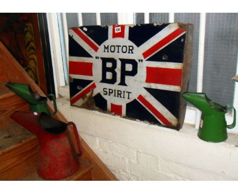 Old enamel sign advertising "BP - Motor Spirit" on a union jack background together with three Castrol oil cans