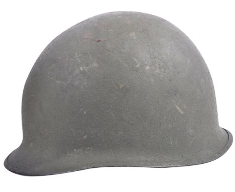 An original WWII Second World War US United States Army M1 fixed bale steel combat helmet.&nbsp;The helmet having a green pai