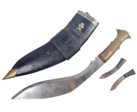 A vintage 20th Century Gurkha Regiment Nepalese kukri knife dagger. Brass grip with ribbed scrollwork and lions head to the p